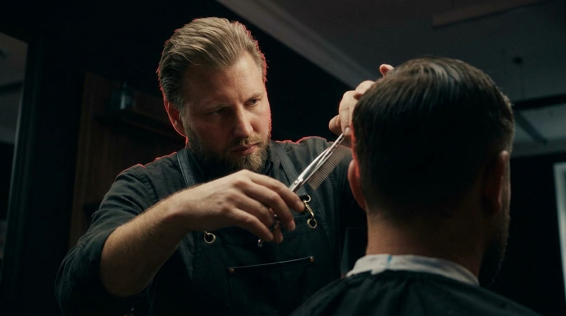 Kirill in der Schürze bei der Arbeit; der Kunde ist nur von hinten zu sehen.